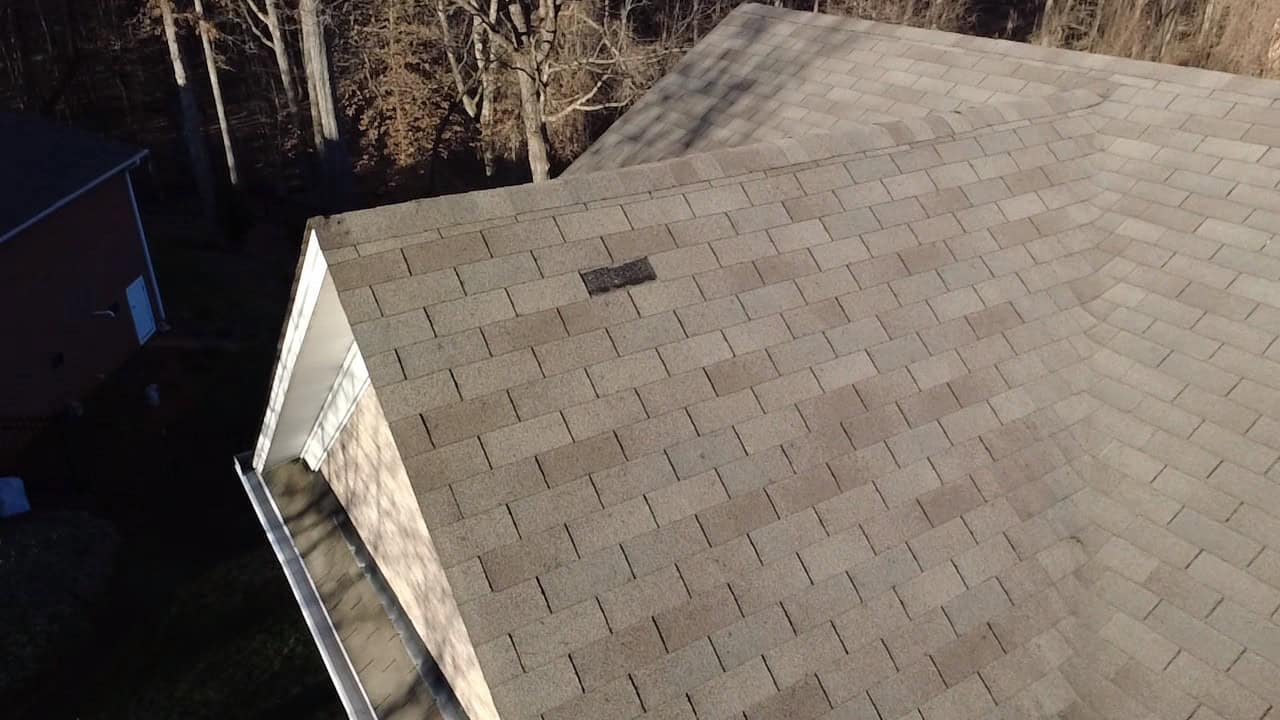 Storm-damaged roof in Greensboro after hail storm